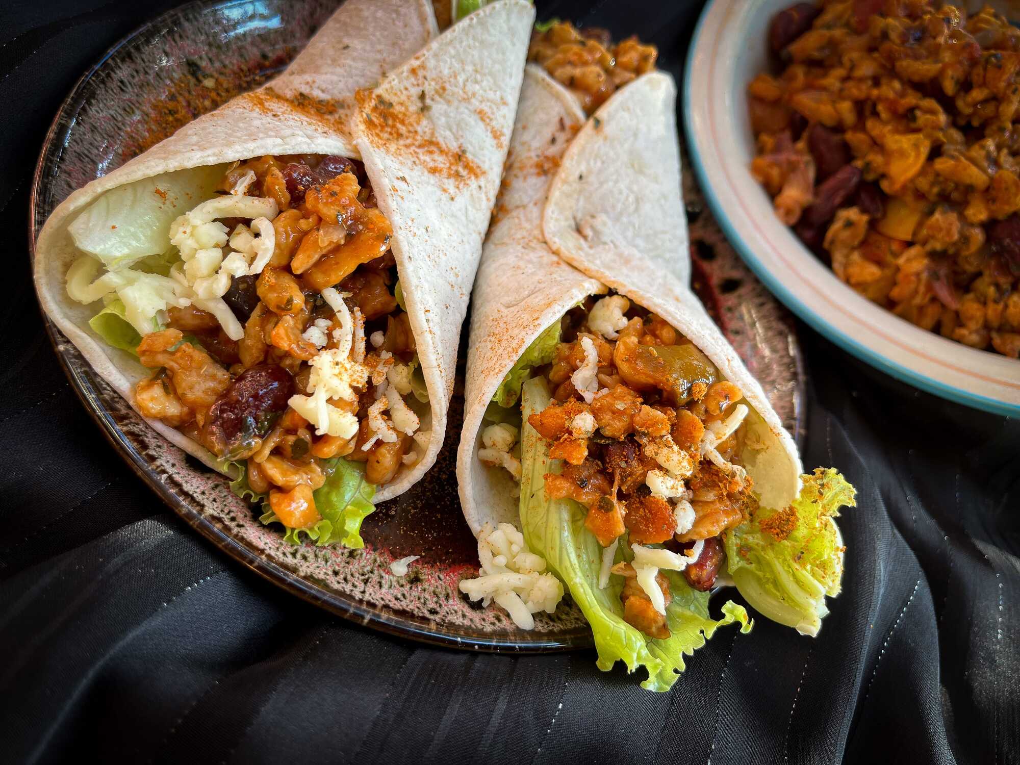 Un petit saladier accueille deux Fajitas aux protéines texturées avec quelques feuilles de laitue.