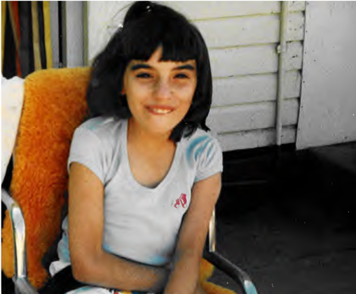 Photo of young Donna sitting on a vernanda.