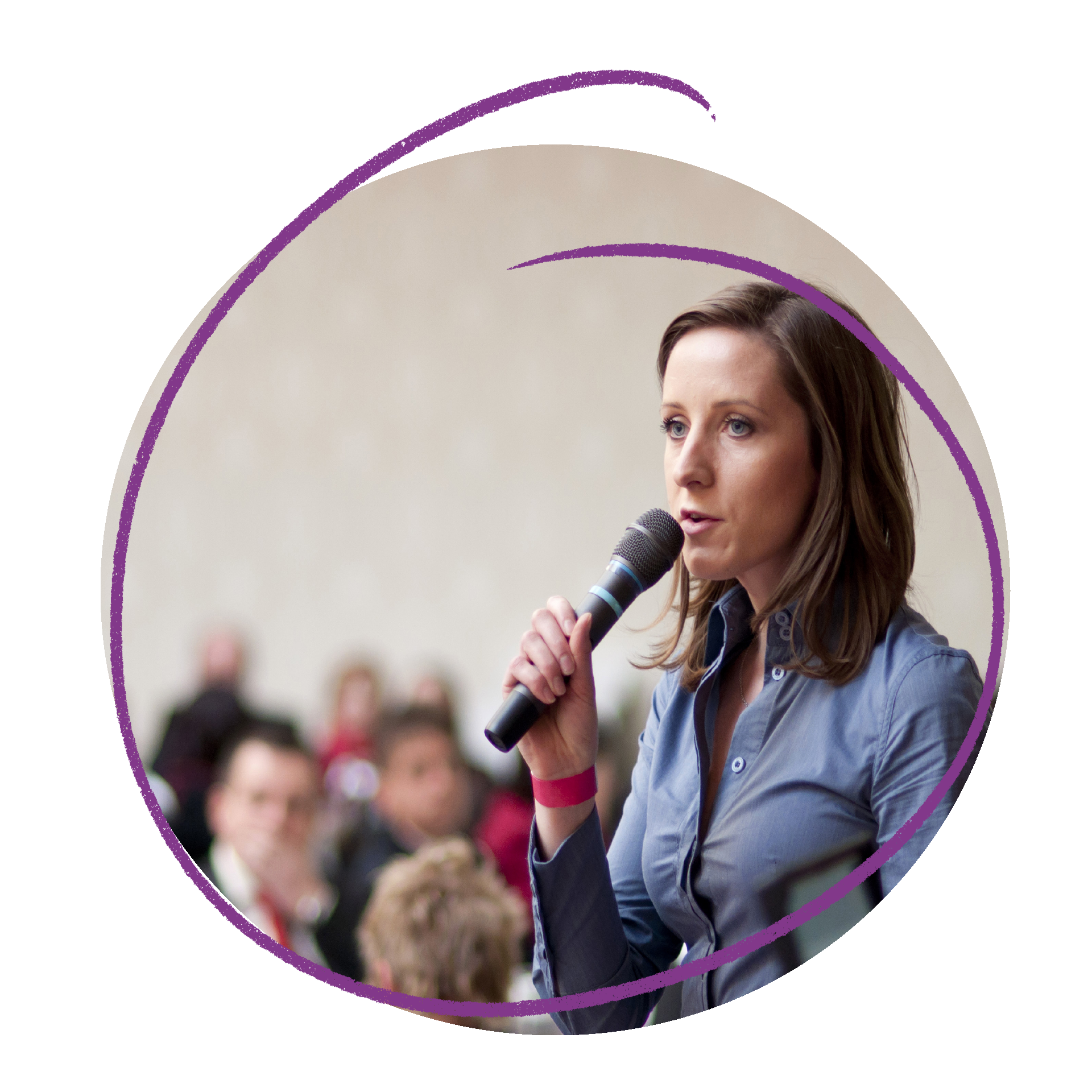 Photo of a young woman speaking into a microphone to a crowd of people.