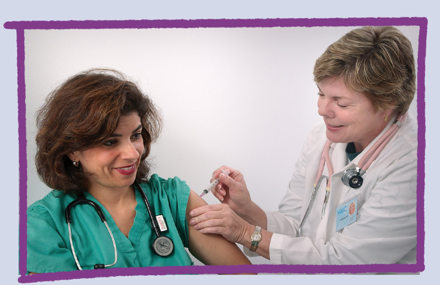 Photo of a doctor giving an injection to a nurse.
