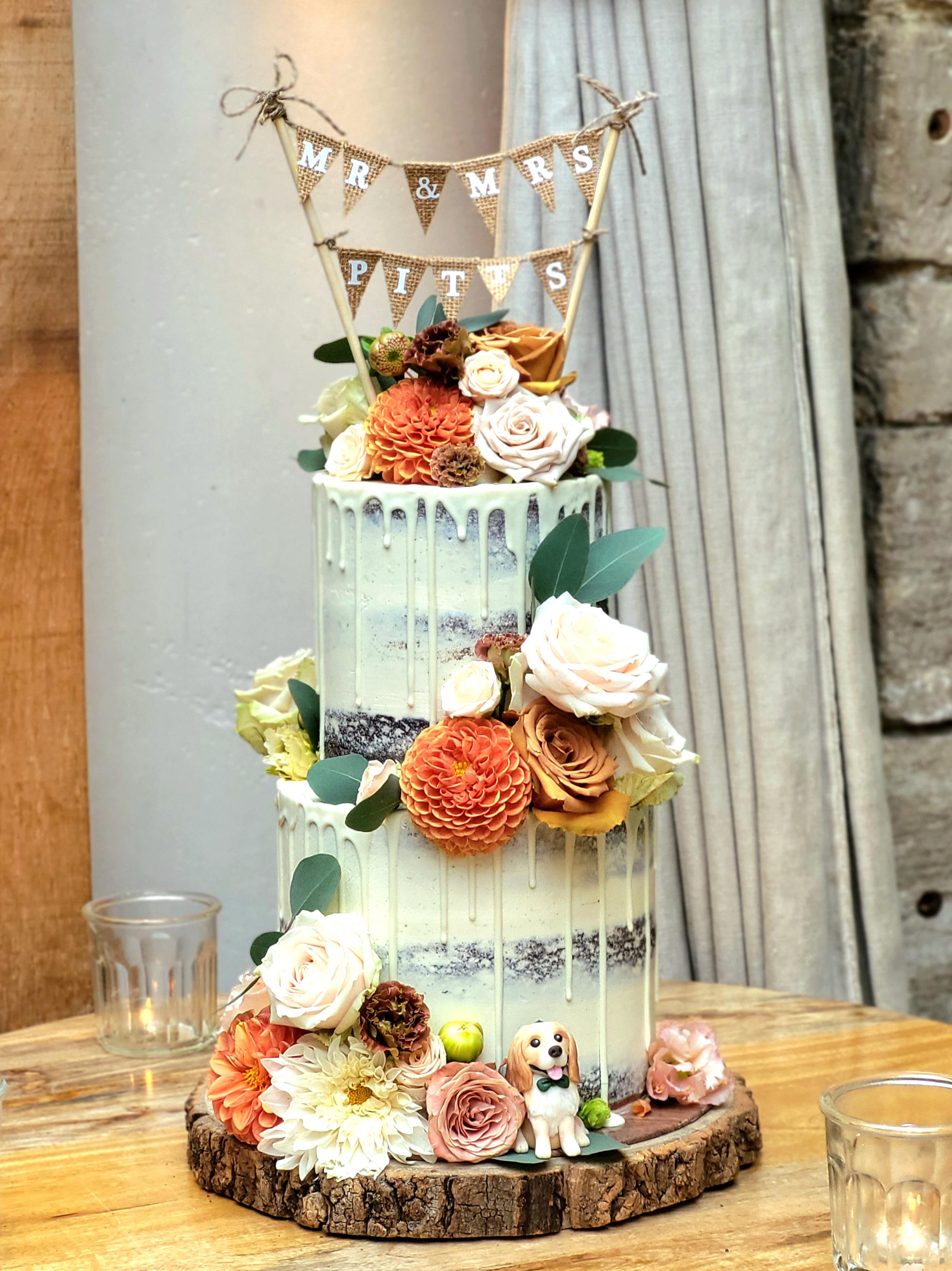 semi-naked chocolate drip wedding cake with bunting and dog