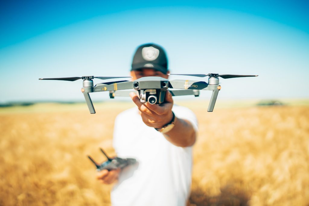 Person holding a drone in a wheat field