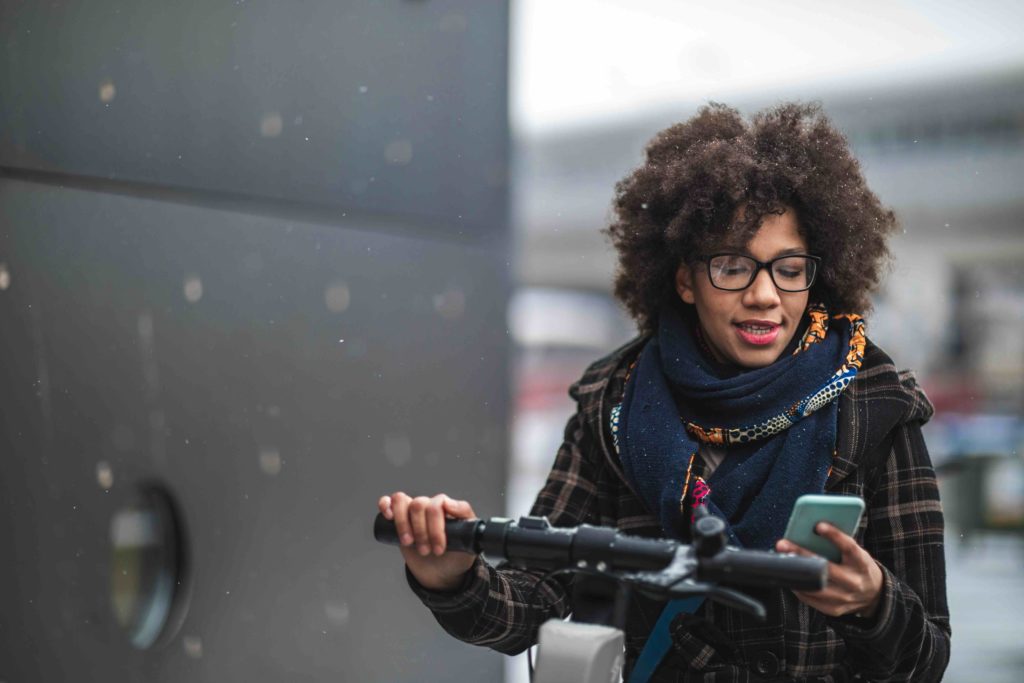 Person checking their smartphone while riding a scooter