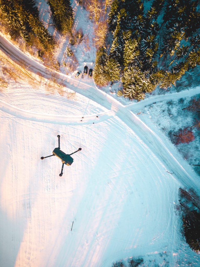 Drone hovering above a snowy field
