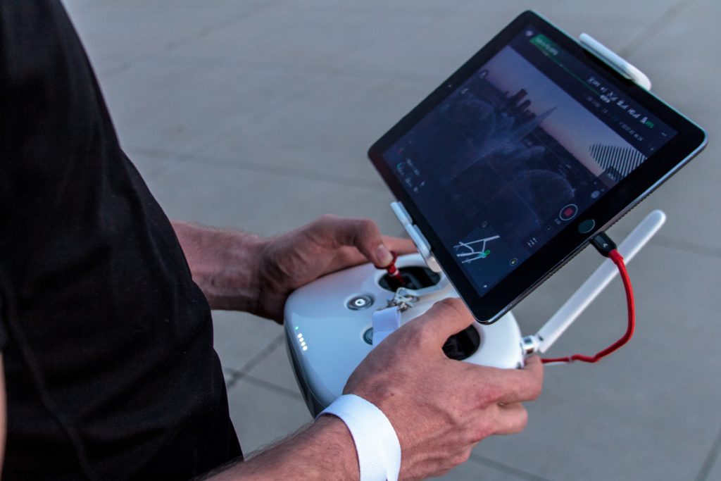Person piloting a drone from a handheld controller