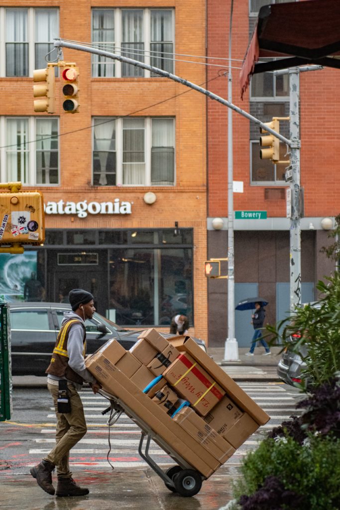 Delivery person wheeling packages on a dolly