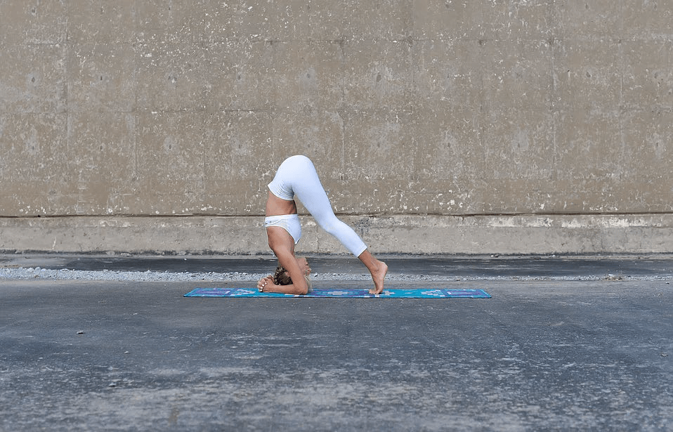 Shift your weight forward for the third step of doing a headstand.