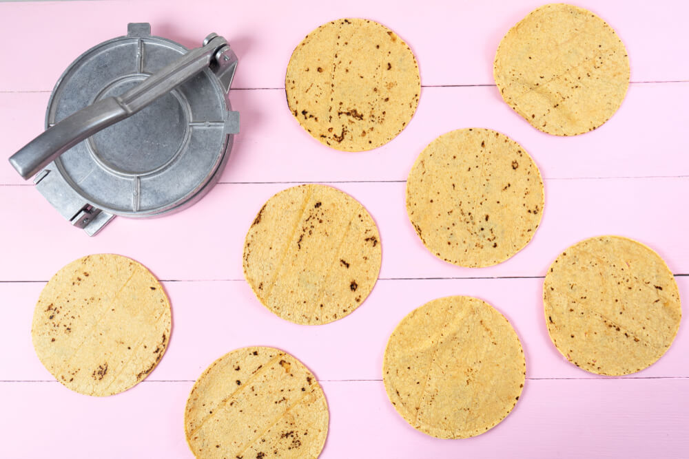 A tortilla press and a few tortillas.