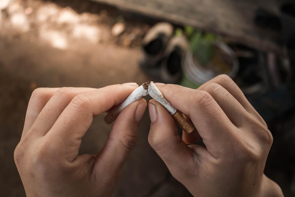 Hands breaking a cigarette.