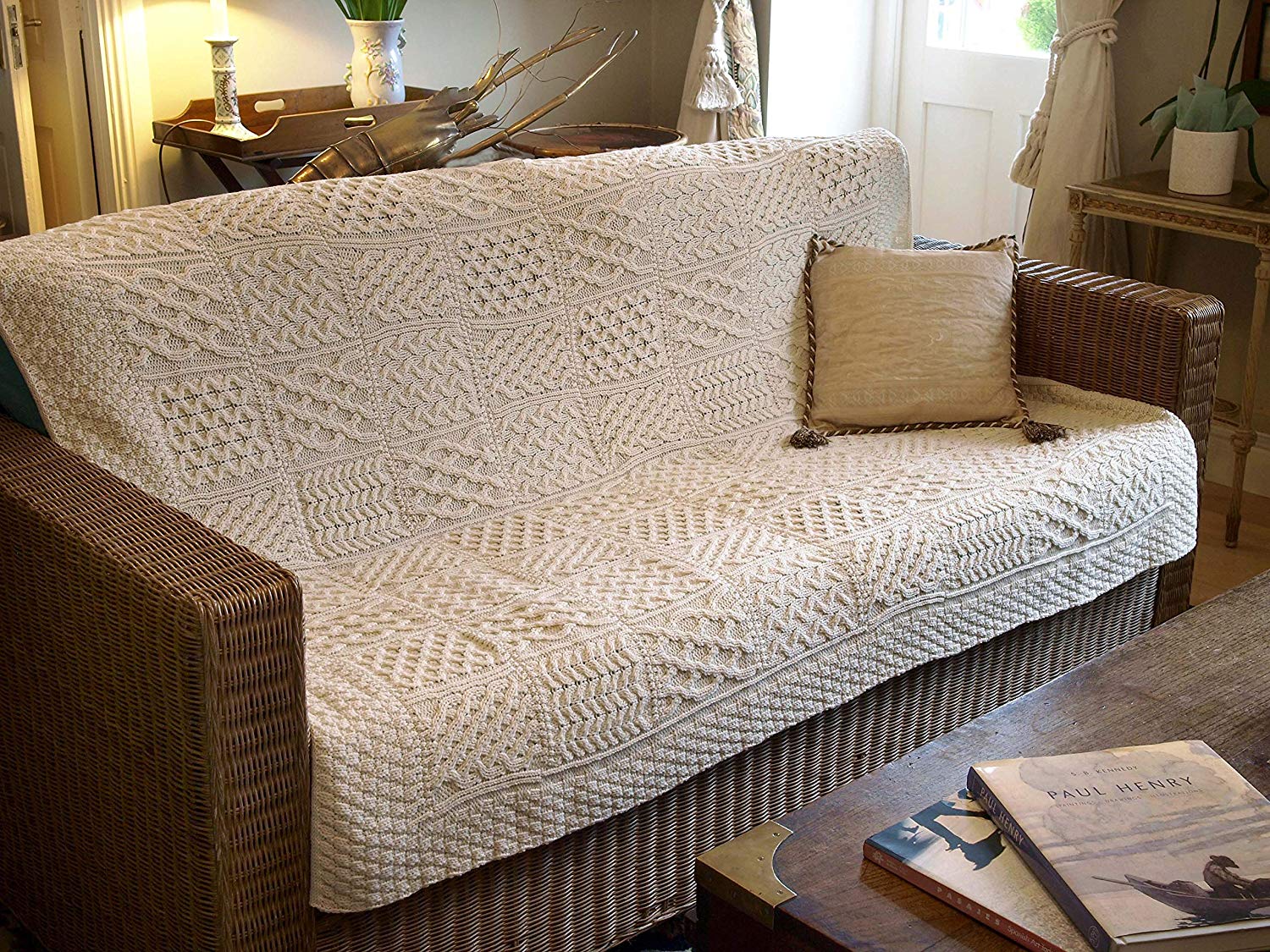 A couch with a large knit blanket on it.