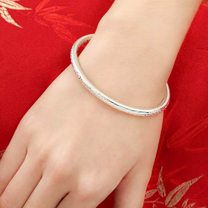 A closeup of the Merdia Sterling Silver Bangle on a woman's wrist.