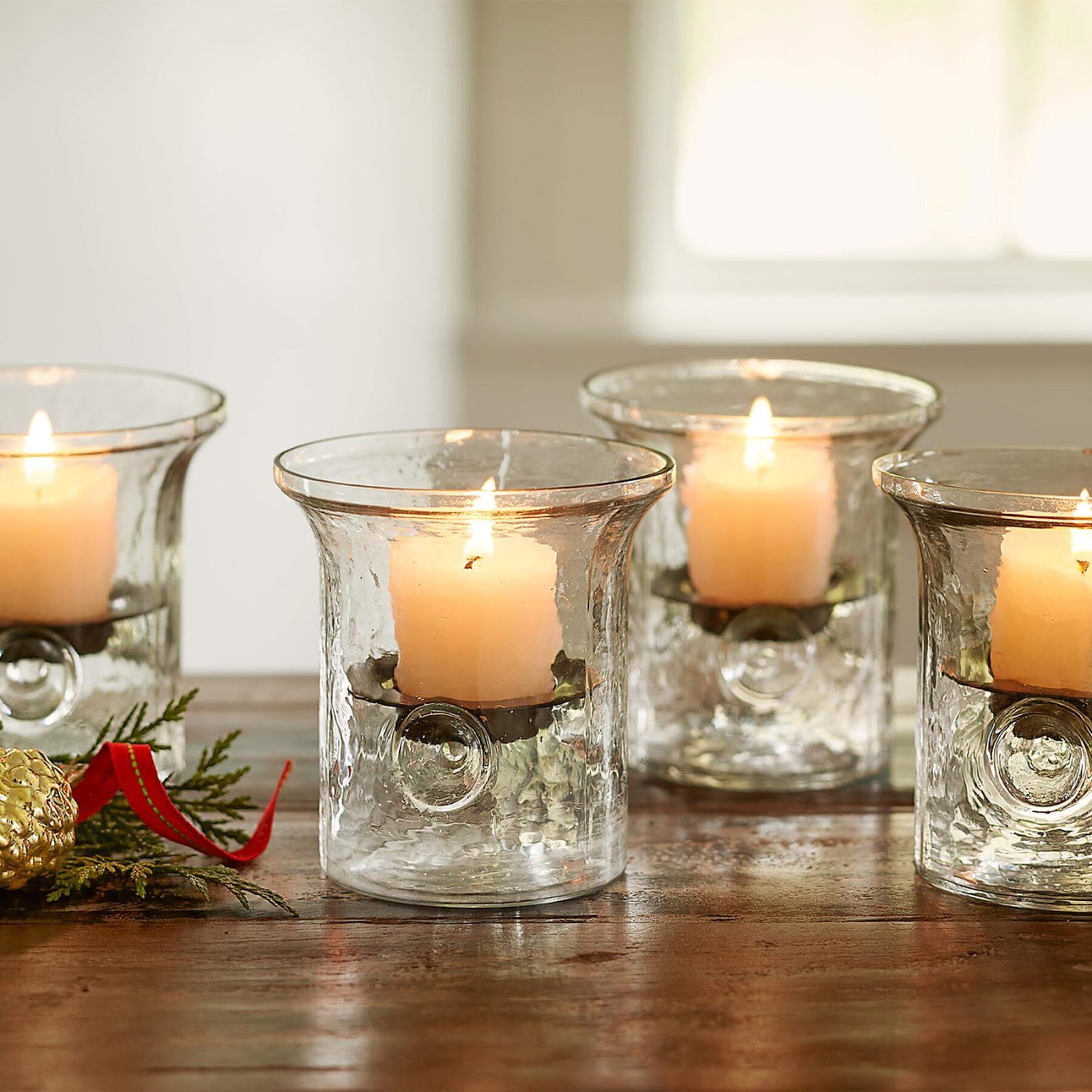 Four Blown Glass Hurricanes with lit candles.