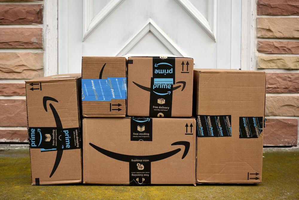 Amazon boxes piled on a doorstep.