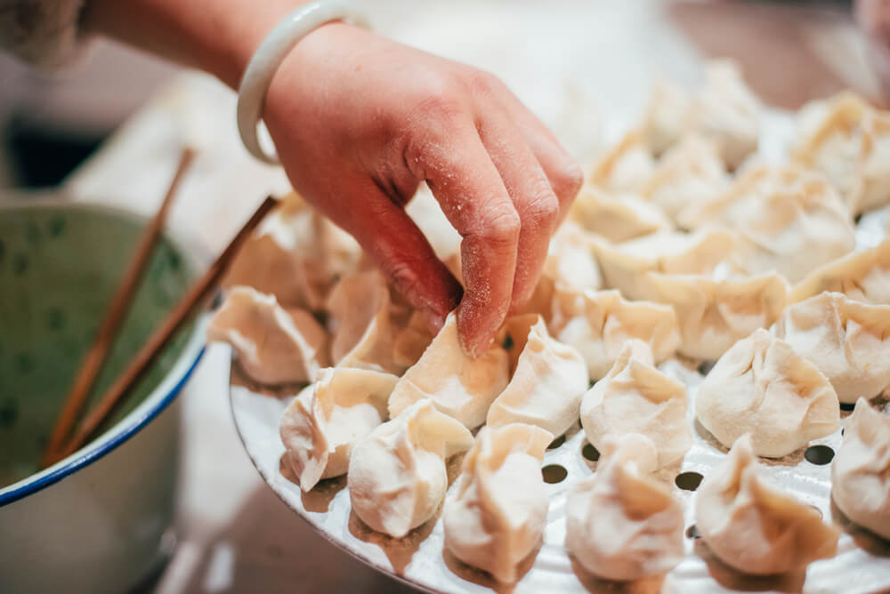 A person making Chinese dumplings.