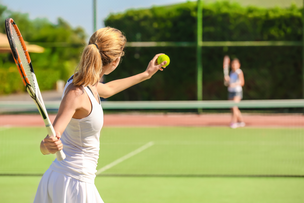 A woman serving a tennis ball.