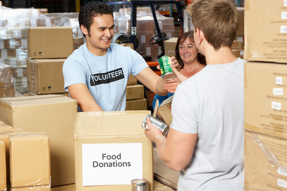 A person collecting food during a food drive.