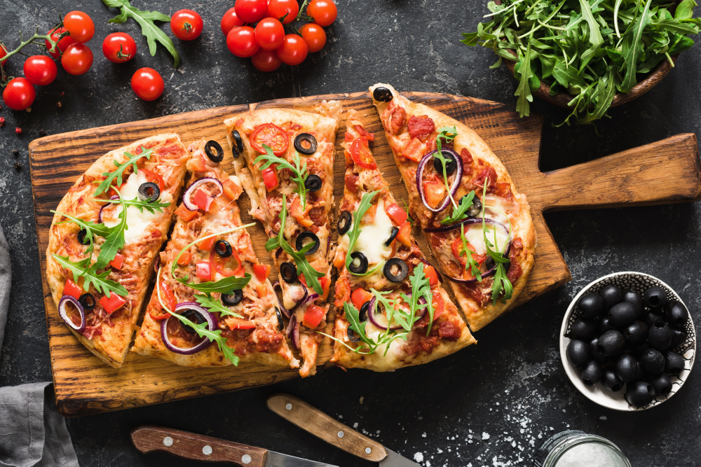 A pizza on a wood plate.
