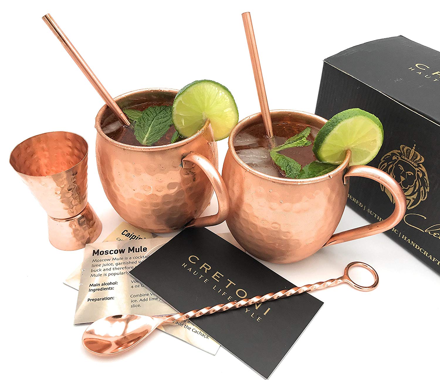 Moscow Mules in brass cups with brass straws and fresh limes.