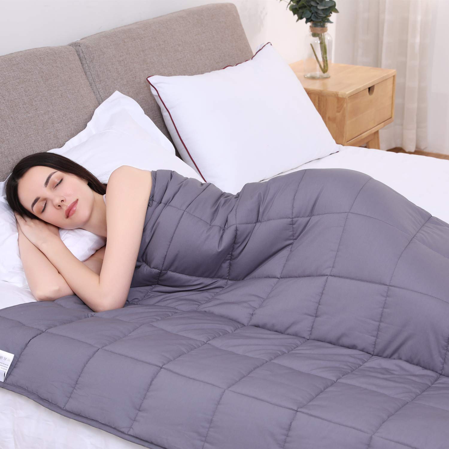 A woman sleeping with a weighted blanket.