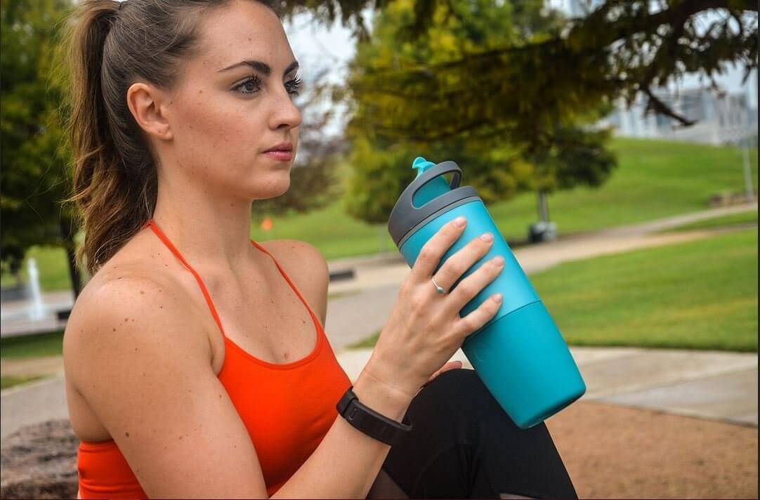 A woman drinking out of her Ozmo Smart Cup.