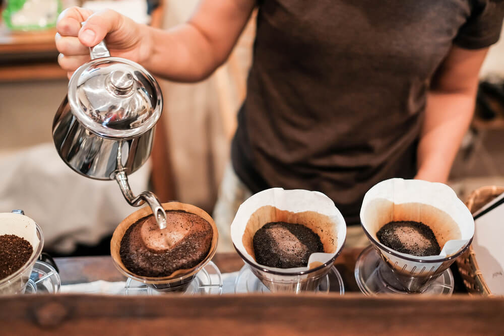 A person pouring water for pour over coffee.