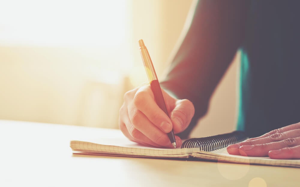 person writing in journal