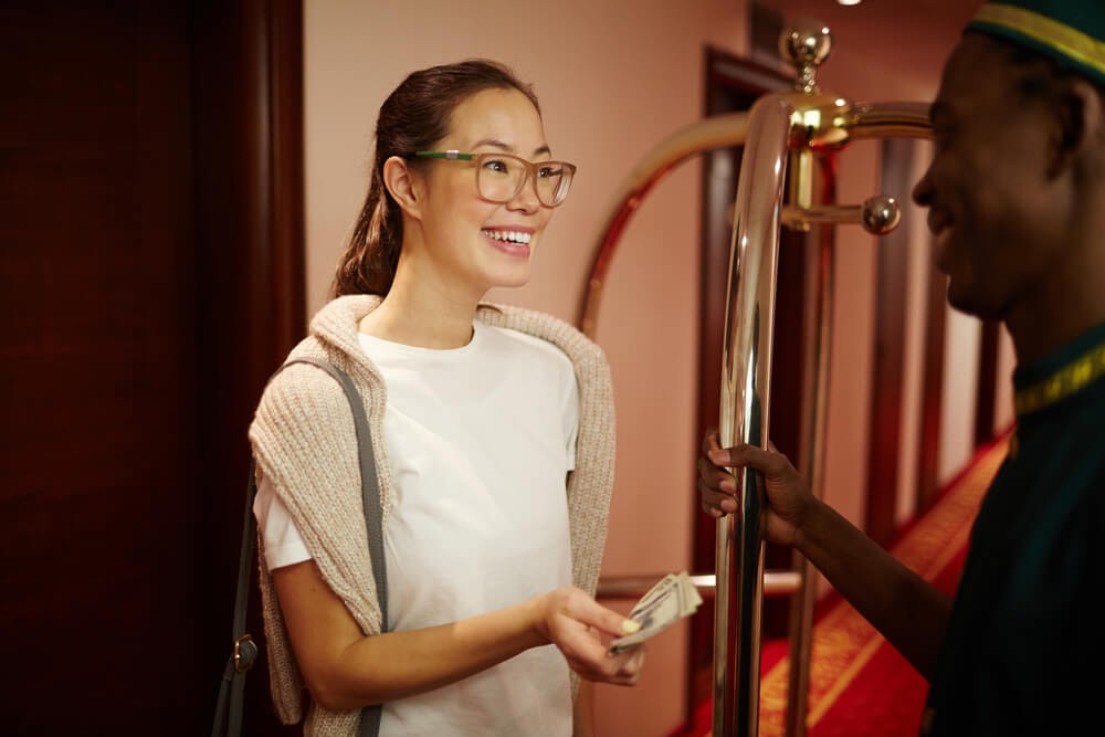 women tipping bellhop at hotel