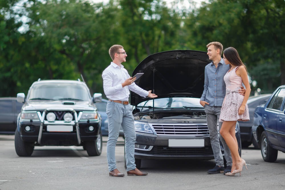 couple talking to car salesman