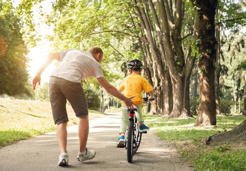 Father teaching his son to ride a bicycle