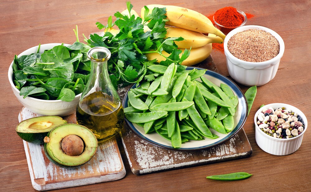 fruits, vegetables, beans, oil and spices on a board