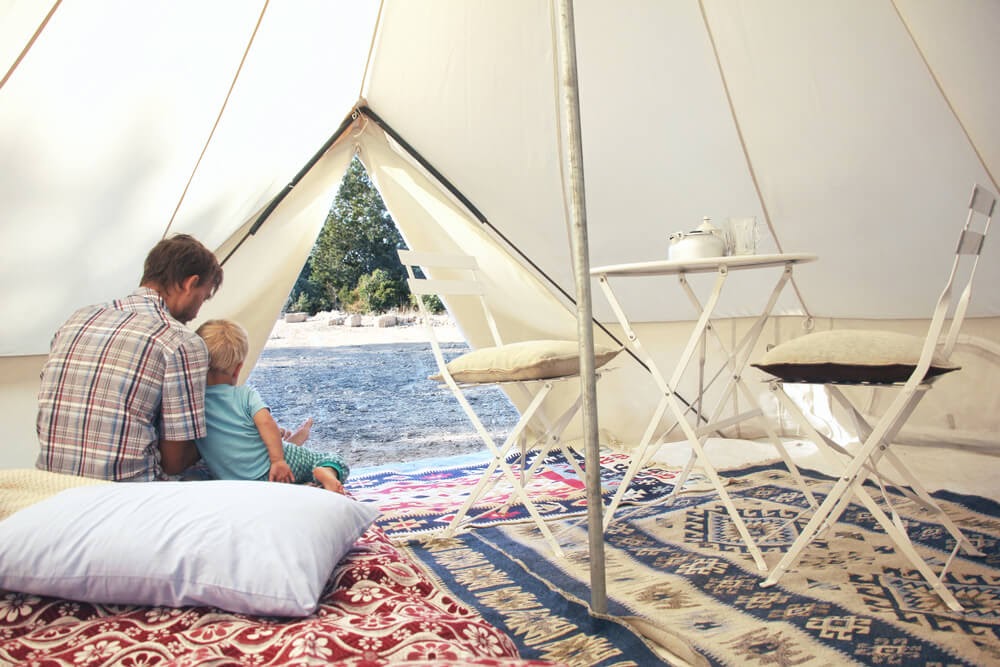 Man in child sit in tent