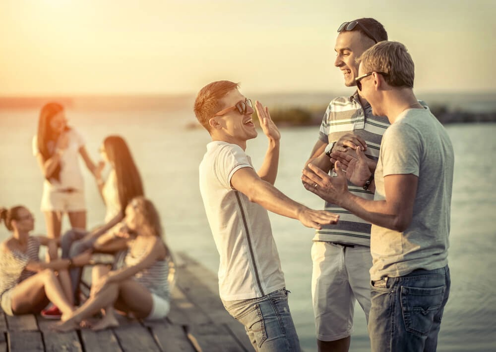 Group of people on a dock at sunset