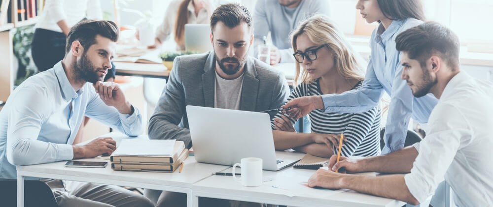Group of professionals working around a laptop