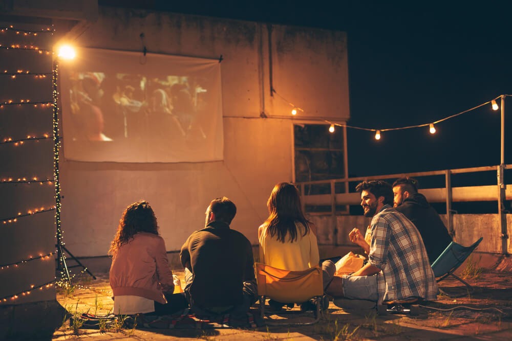 Group of people watching movie projected outdoors