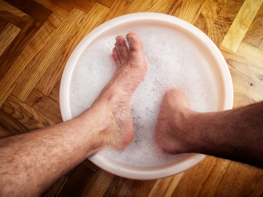 Bare feet soaking in soapy water