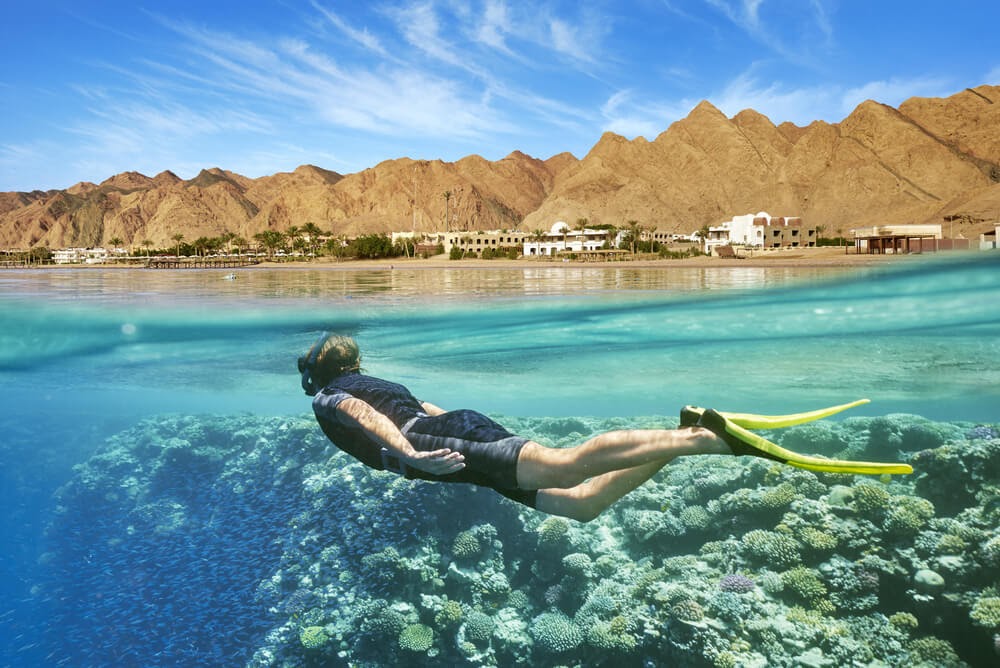 Half underwater angle of person snorkeling near the surface