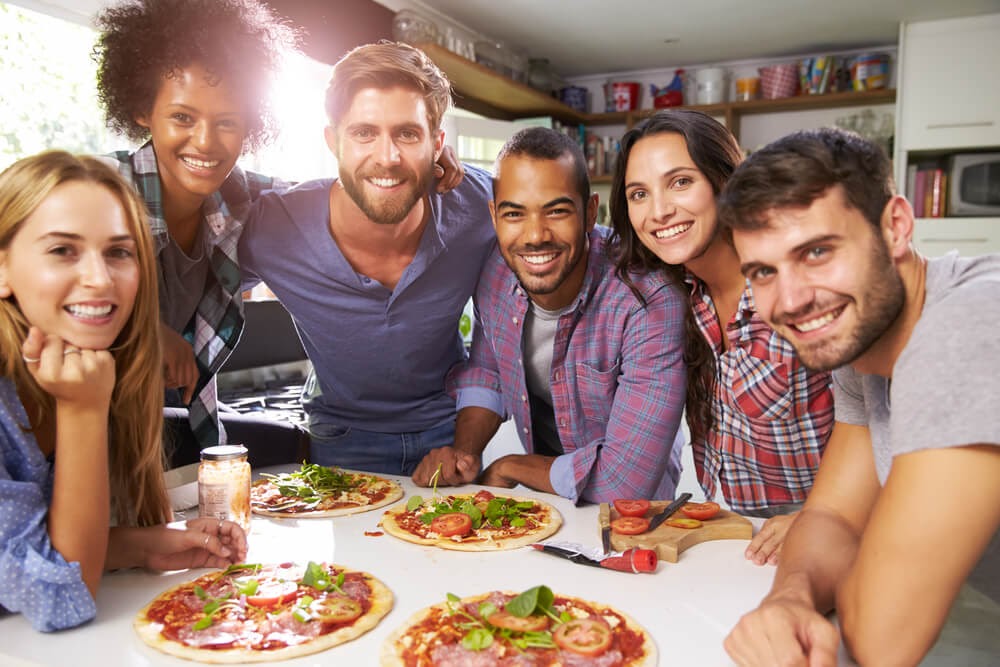 group of friends making pizza