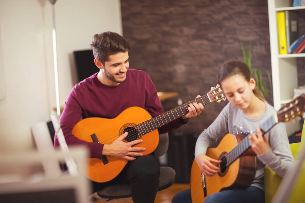 Two people playing guitar.