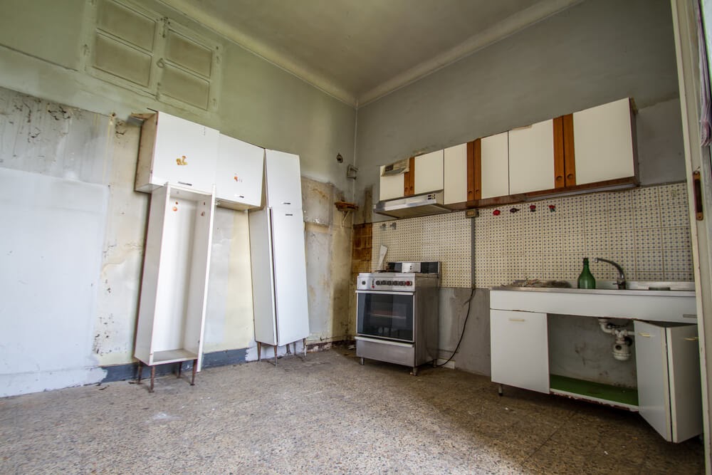 A kitchen that has been stripped and needs repair