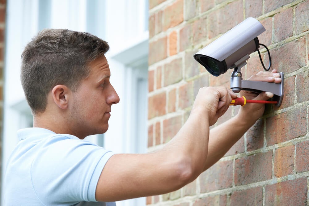 man installing a security camera