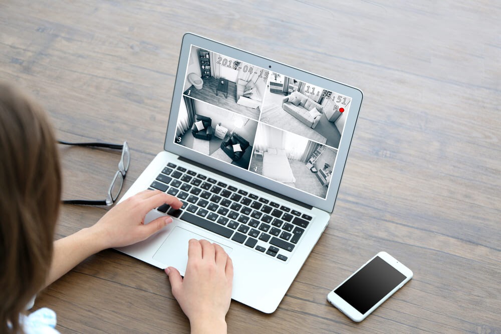 woman looking at security video on laptop