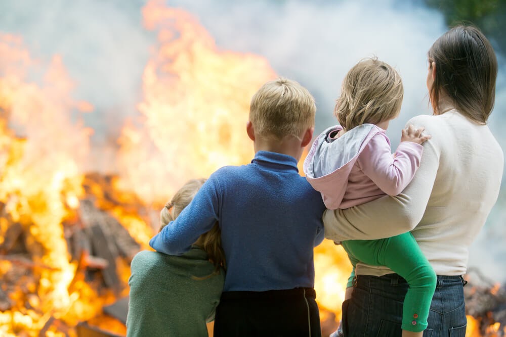 Family looks onto large fire.