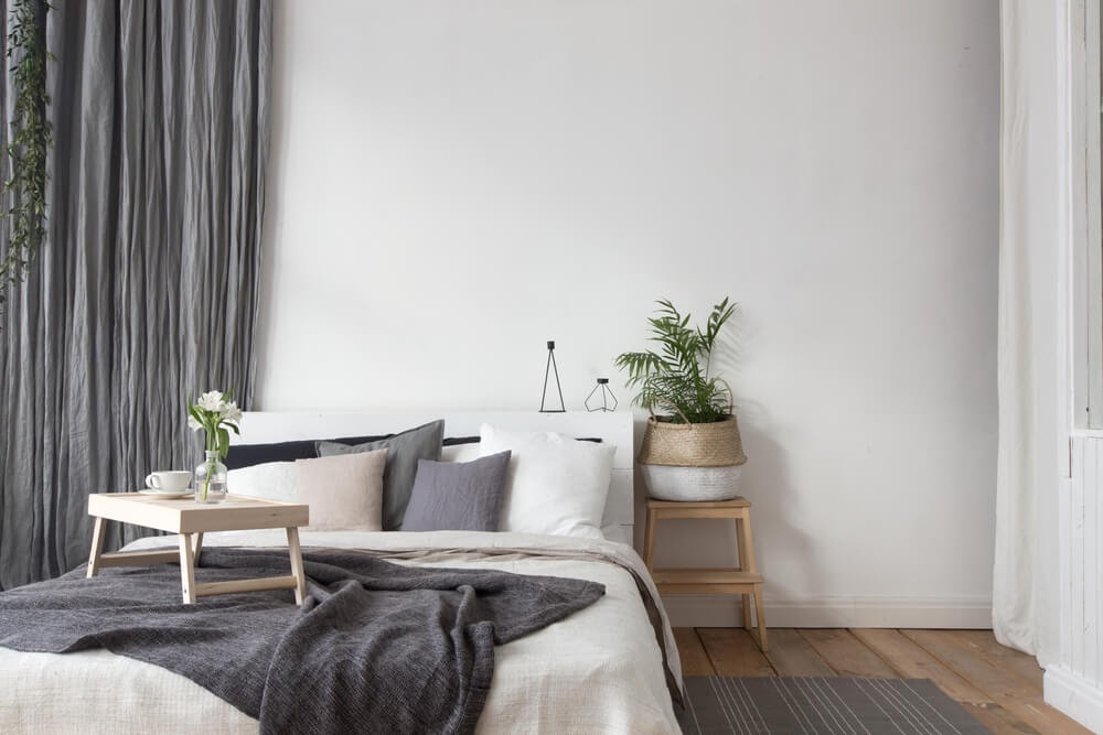 White & grey bedroom with greenery to accent.
