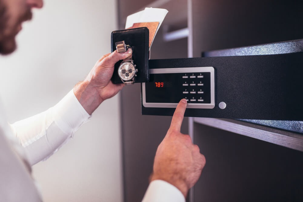 Man putting valuables into a safe.