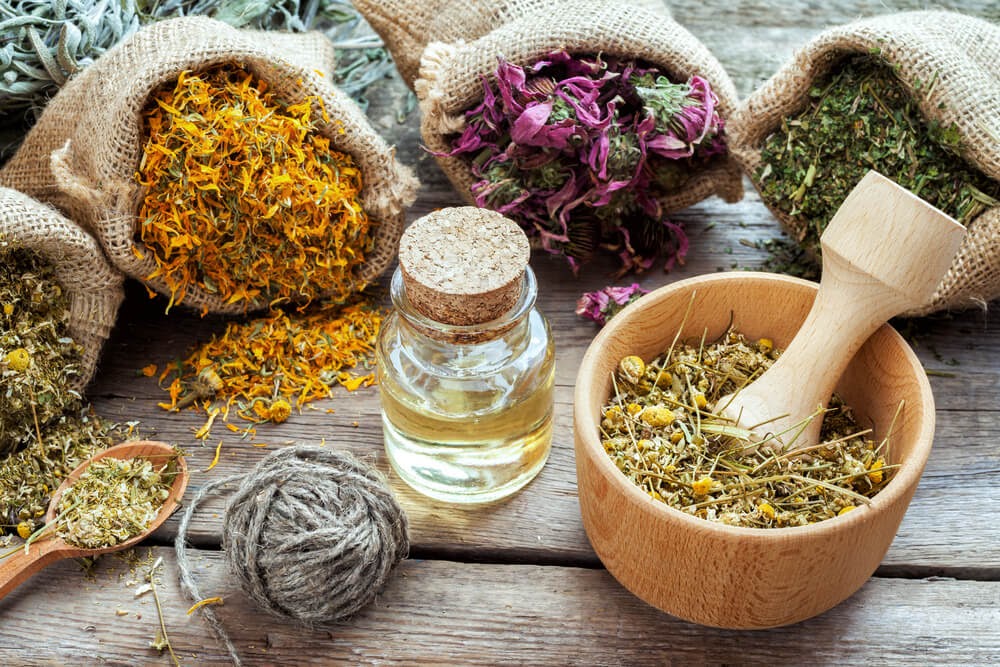 Various colorful herbs in burlap sacks.