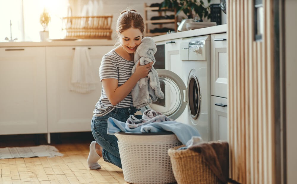 Woman pulling towles out of the dryer.