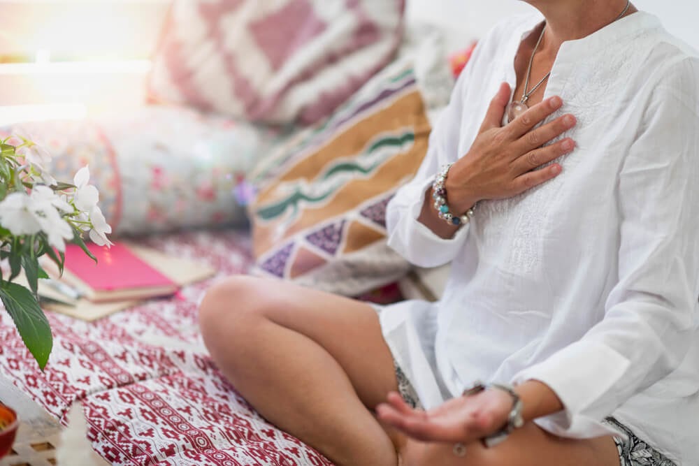Person sits in what looks like a meditation pose.
