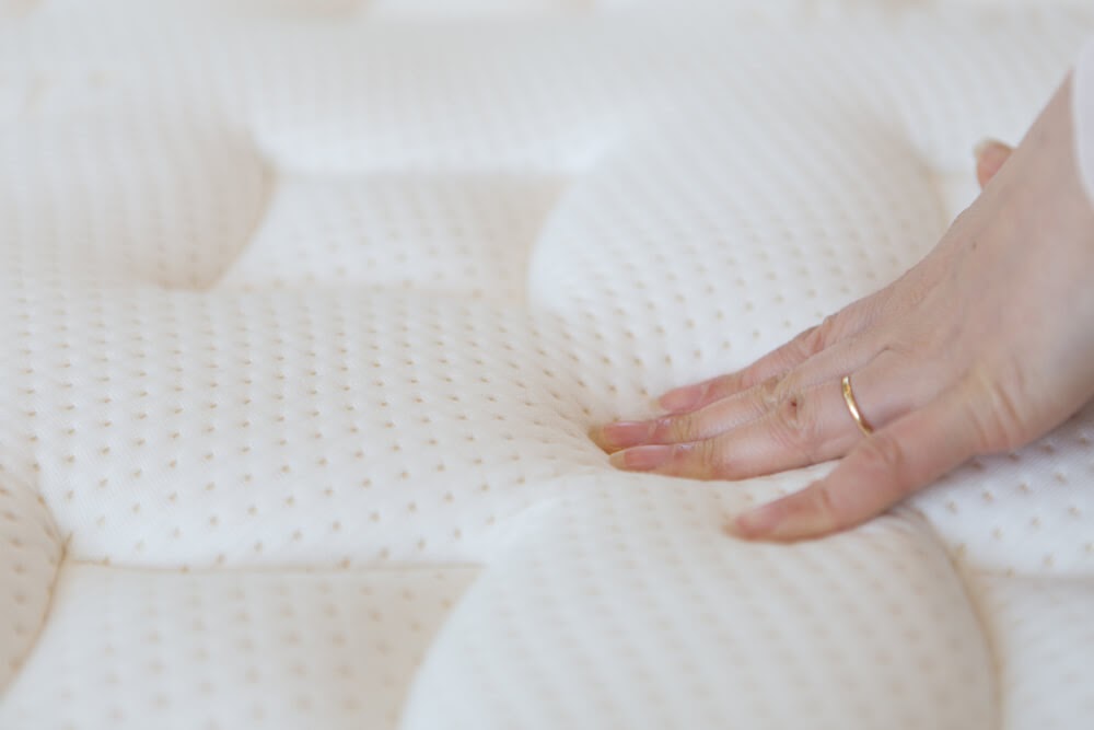 Woman's hand pressing on a mattress