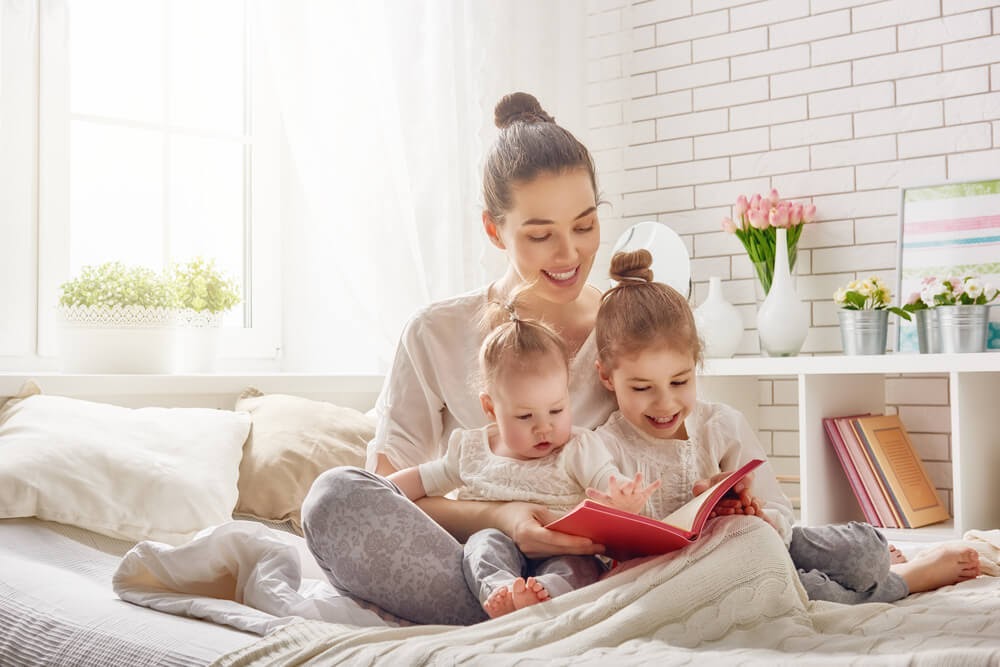 Mom reading to two toddler girls