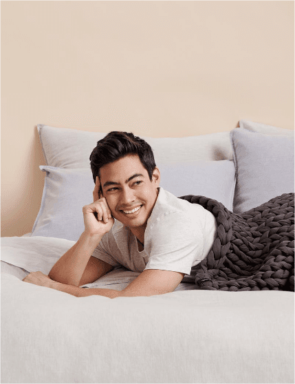 Man wrapped up in weighted blanket on bed